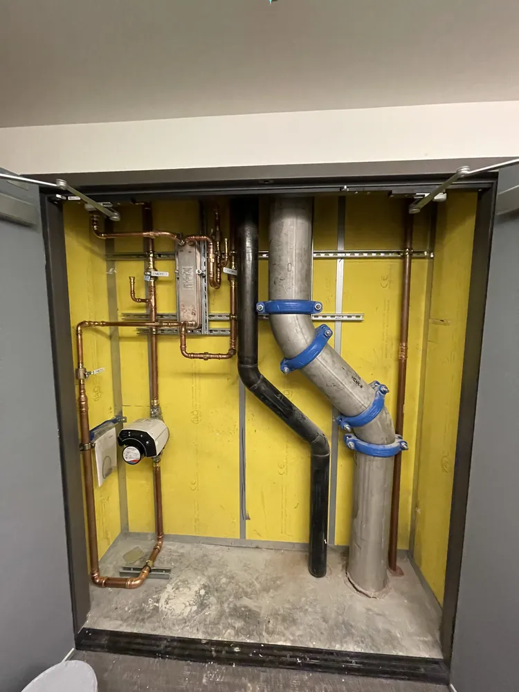 Bath suite plumbing rough-in with copper supply lines and drain stack in a custom residence
