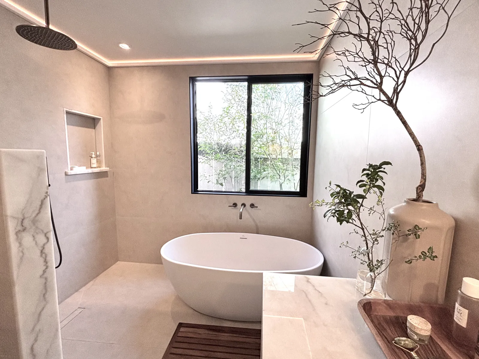 Freestanding soaking tub with wall-mounted tub filler in a Southern California luxury bathroom plumbed by Poseidon Plumbing
