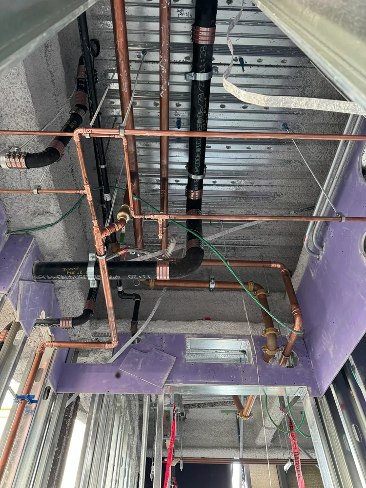 Overhead copper supply and drain piping installed during a high-end remodel by Poseidon Plumbing