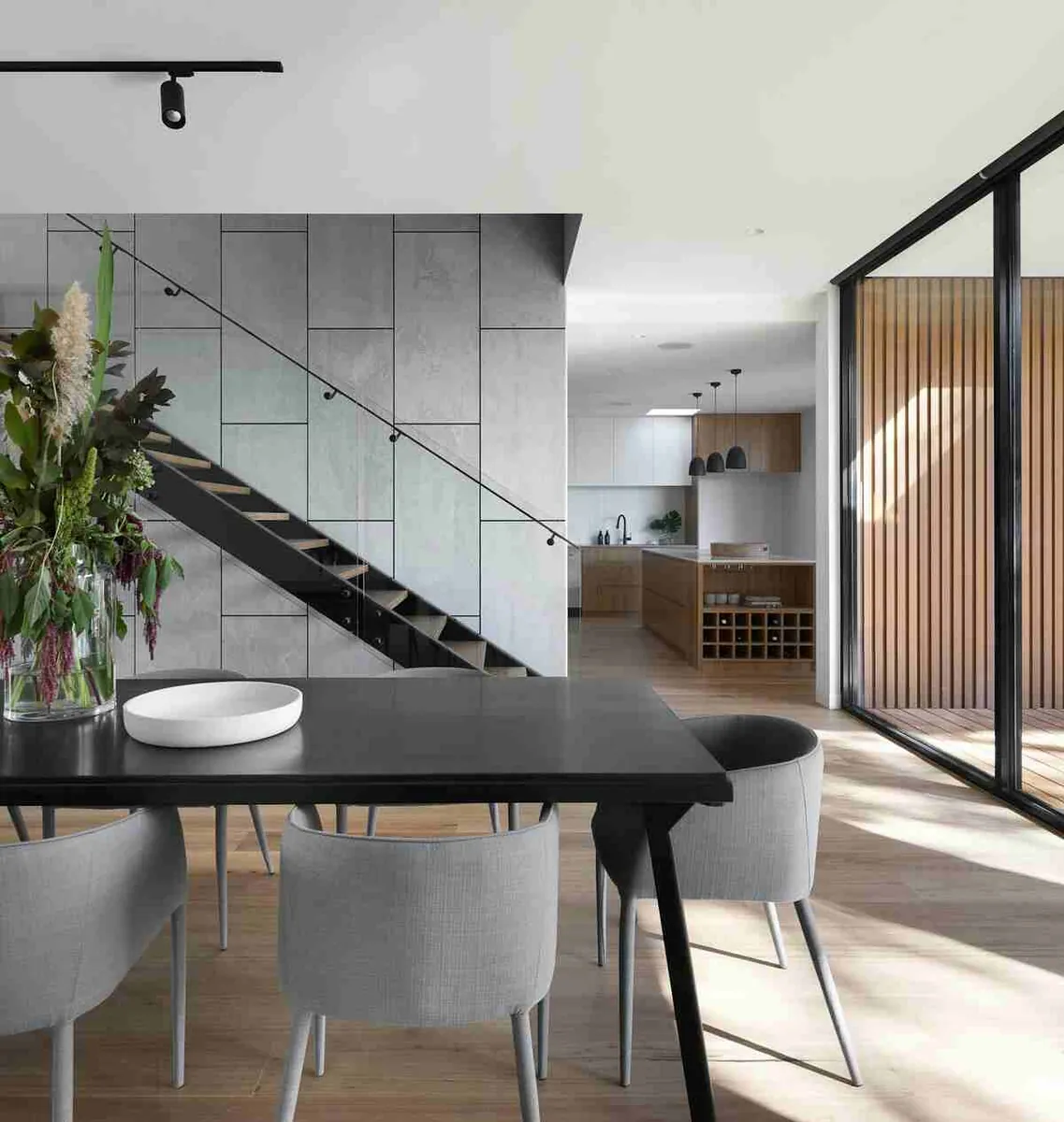 Contemporary luxury home interior with floating staircase, kitchen and dining area