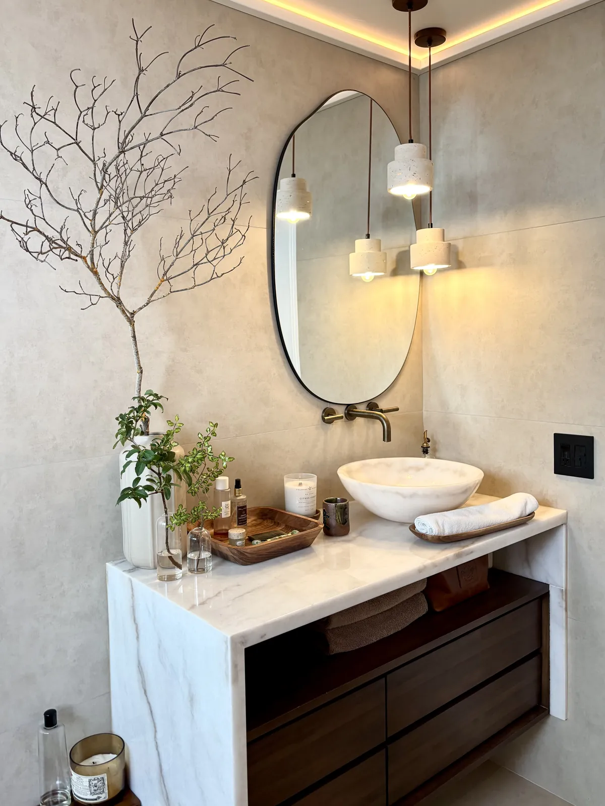 Luxury powder room with vessel sink, wall-mounted brass faucet and marble waterfall vanity in a Southern California estate