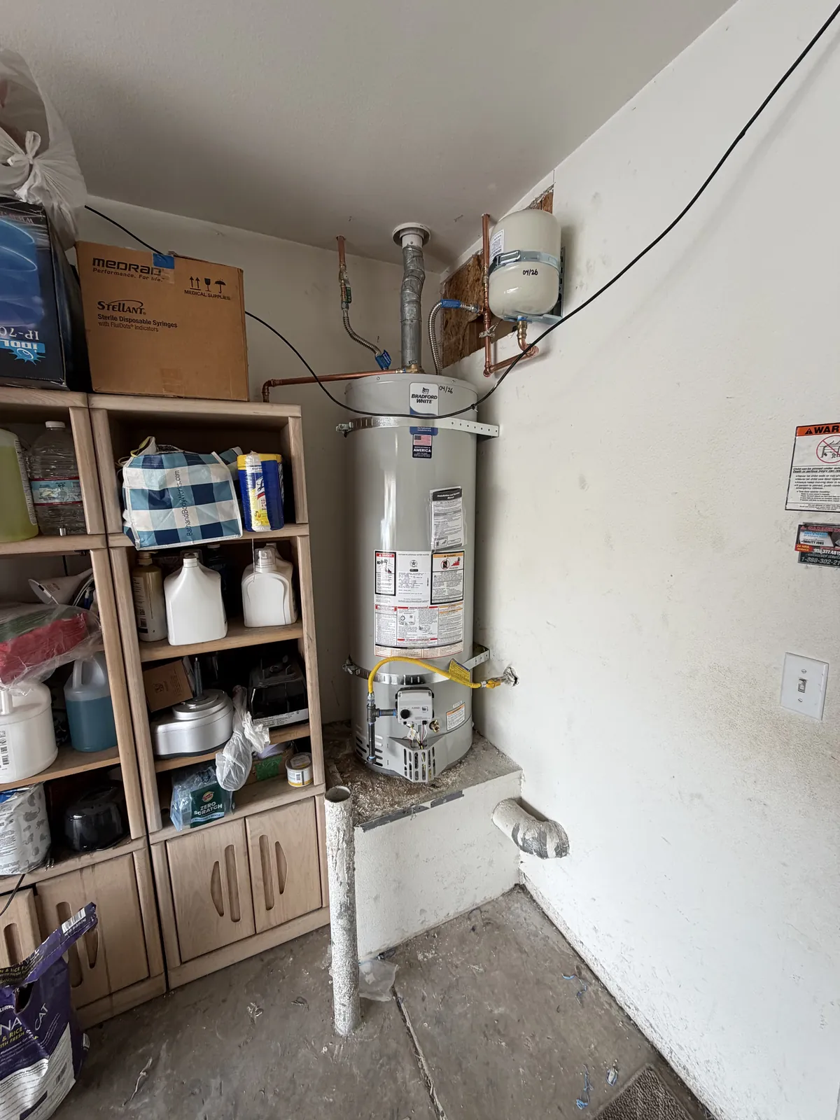 Residential tank water heater with copper supply lines, expansion tank and gas connection installed by Poseidon Plumbing in a Southern California home